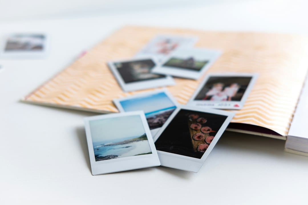 Instant photos spread across an open photo album on a white table