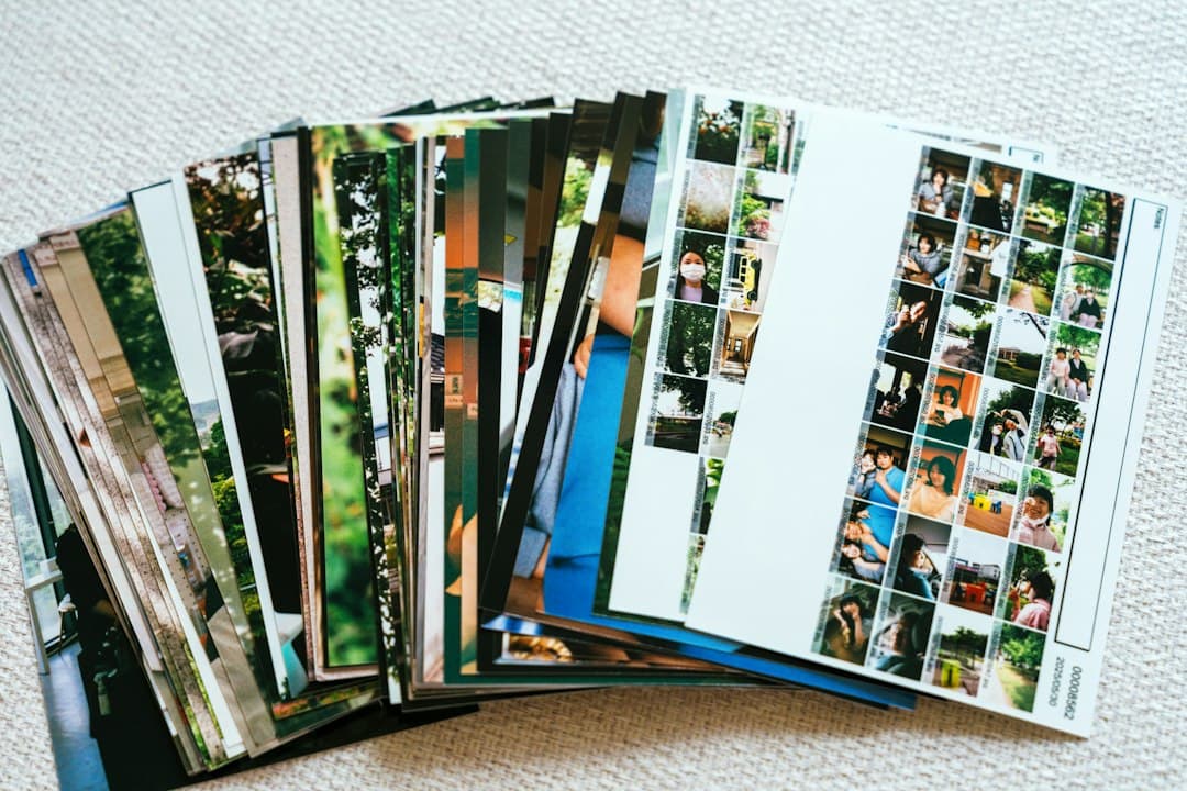 A stack of printed photographs fanned out on a light carpet